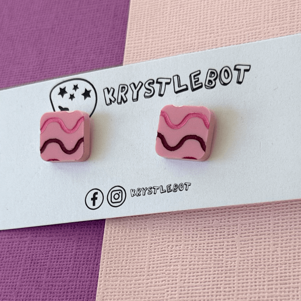 Pink square earrings with wavy lines on a Krystlebot branded card.