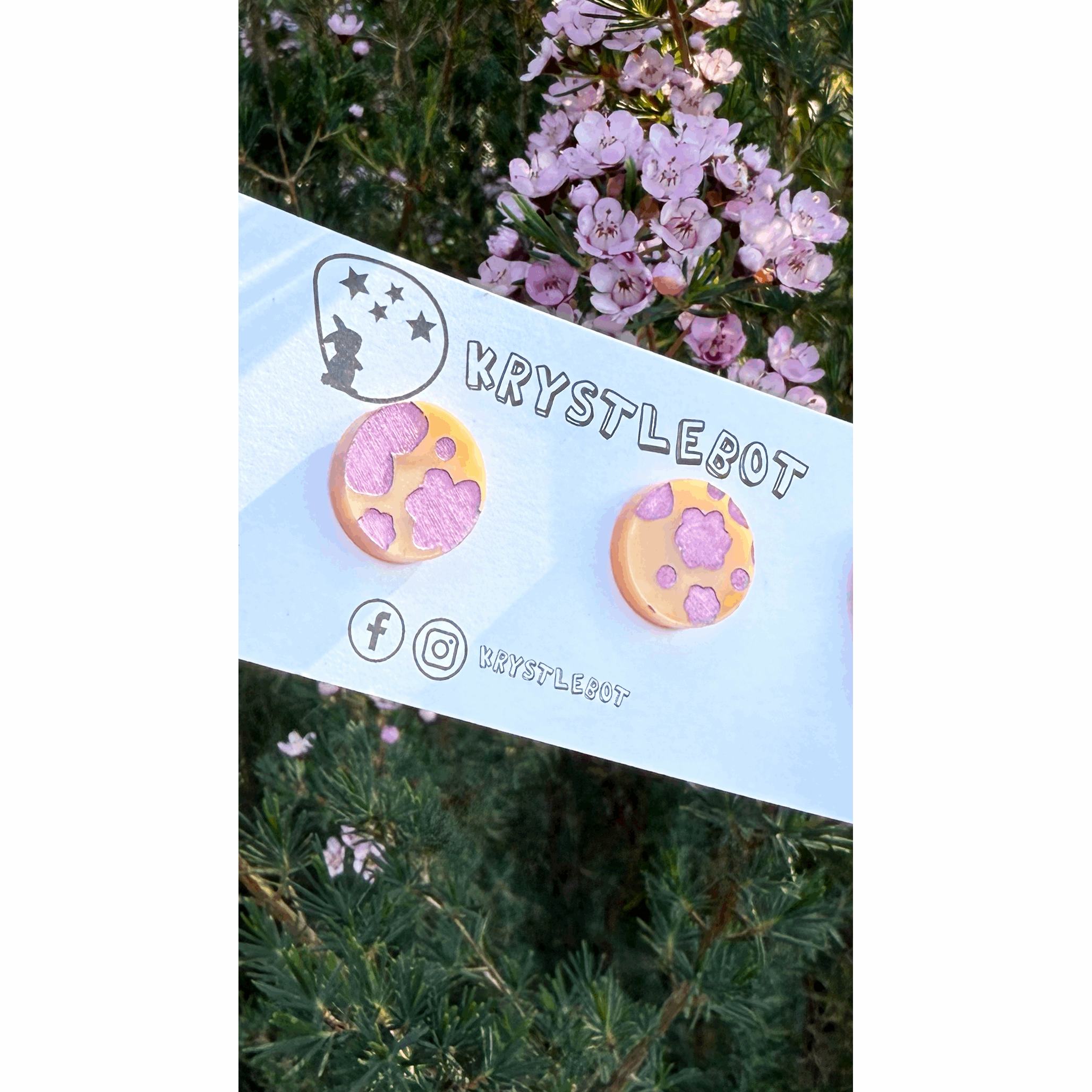 Pair of circle round orange acrylic earrings hand painted with pink metallic abstract flowers