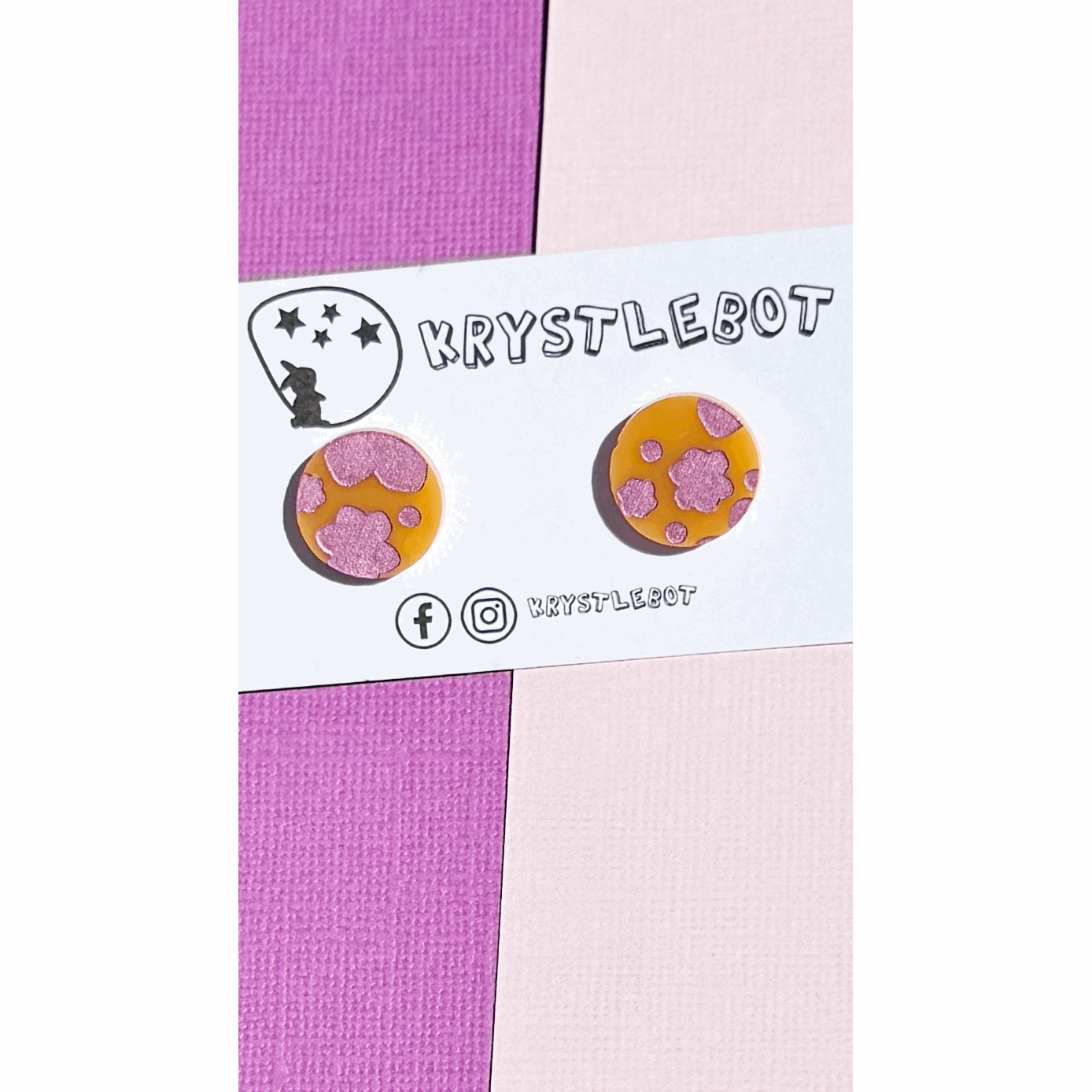 Pair of circle round orange acrylic earrings hand painted with pink metallic abstract flowers