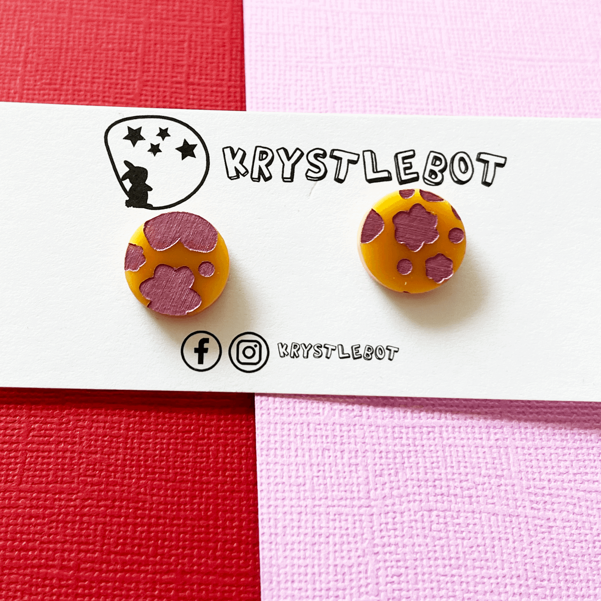 Pair of circle round orange acrylic earrings hand painted with pink metallic abstract flowers